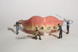 Miniature workers performing dental procedures. dental office ar